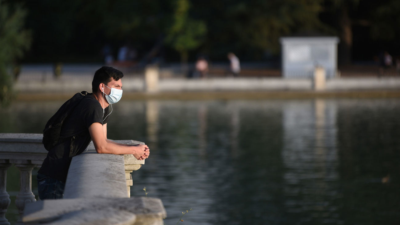 Un joven se asoma al estanque de El Retiro
