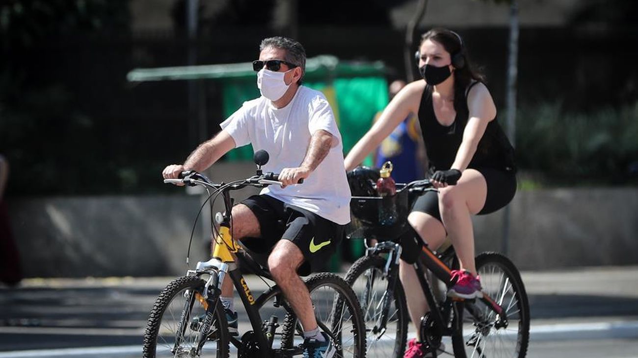 Dos personas montan en bicicleta con su mascarilla puesta