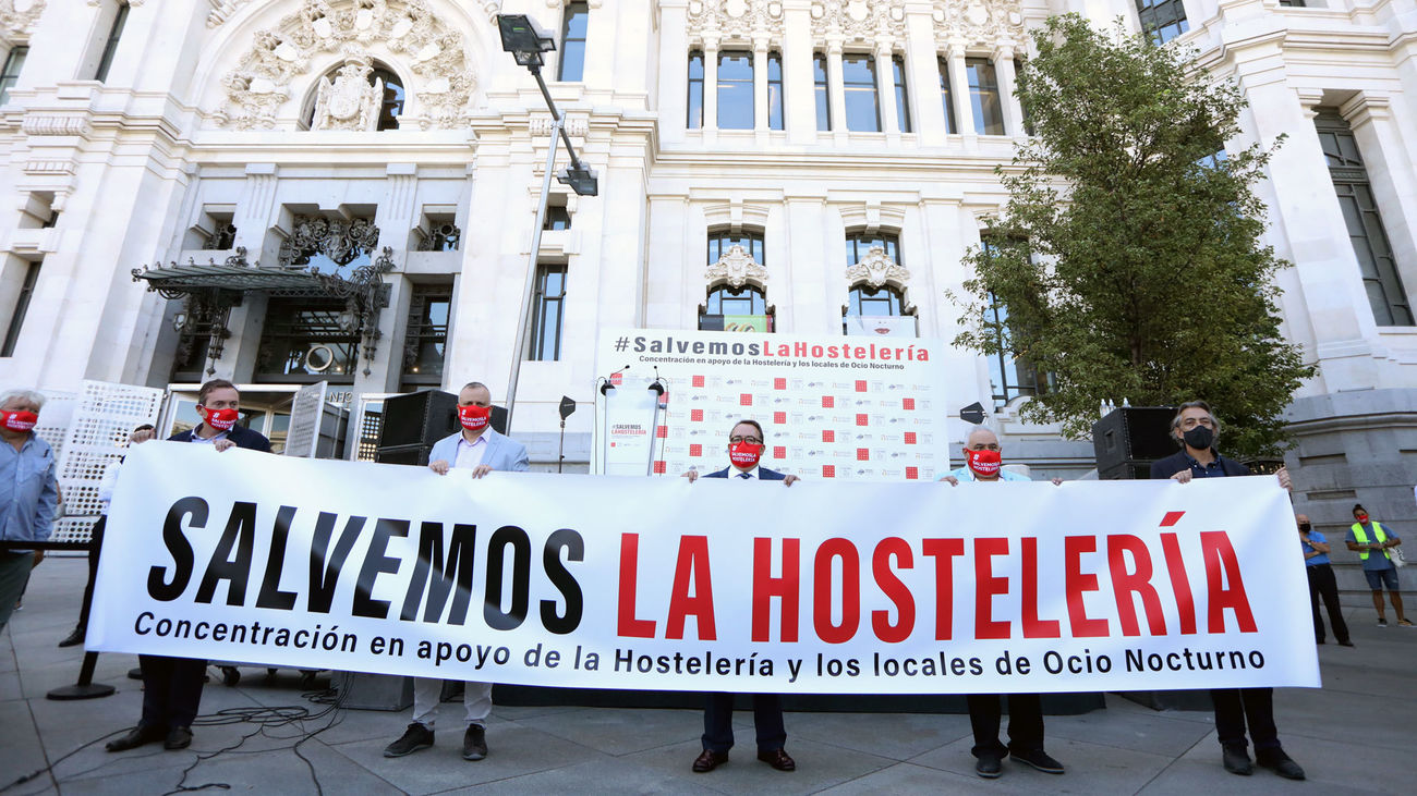 Representantes de la hostelería sostienen una pancarta que pide medidas de apoyo al sector ante el Palacio de Cibeles