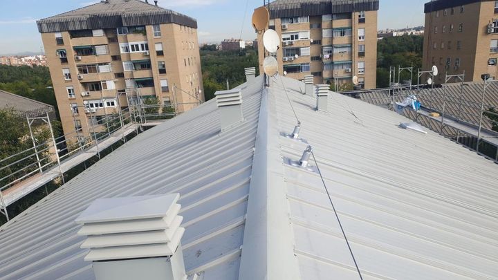 En primer plano el nuevo tejado de un inmueble. Al fondo, edificios con uralita / AAVV ORCASITAS