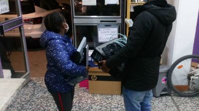Vecinos de Aluche recogen y entregan ordenadores en las 'colas de la tecnología'