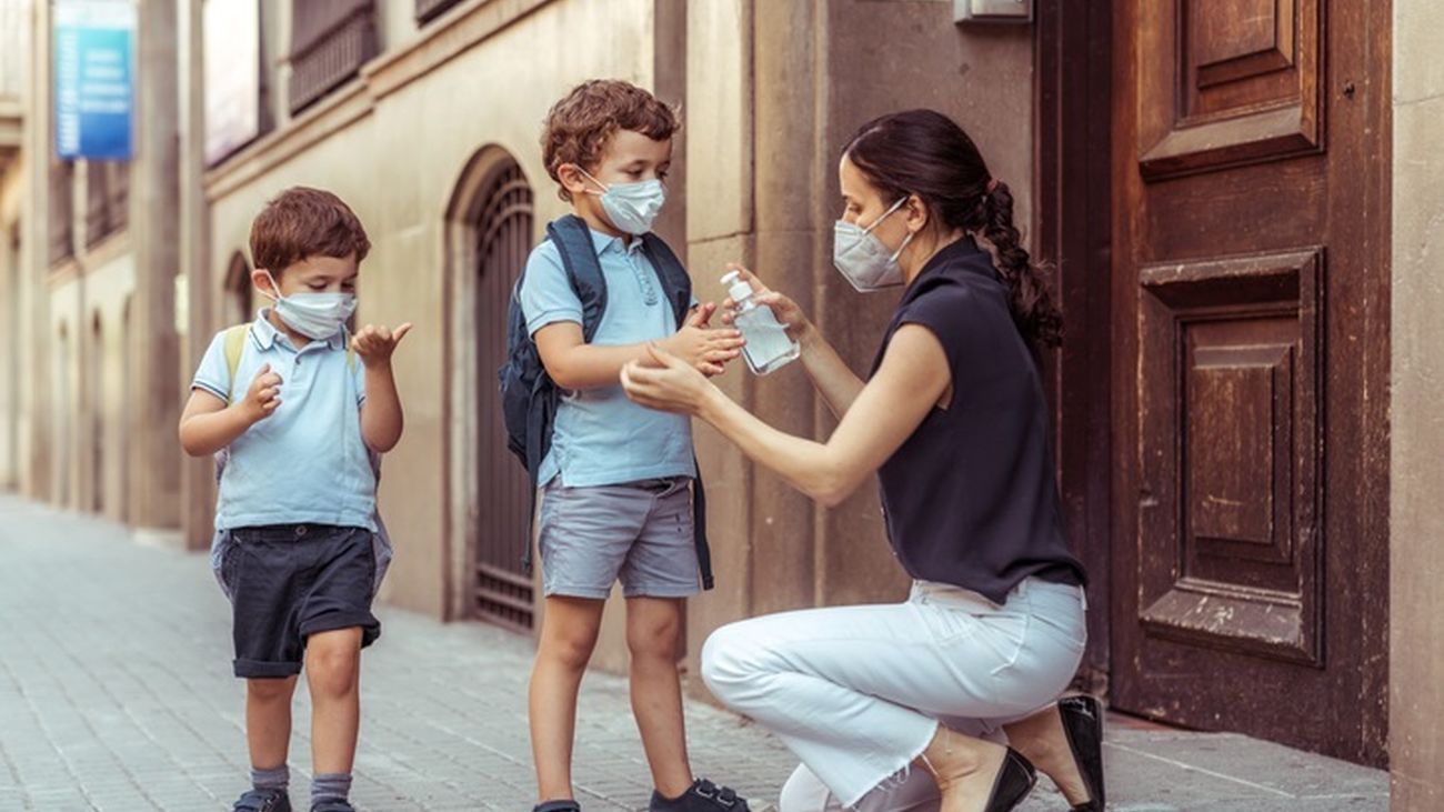 Madre echando a sus hijos gel hidroalcohólico