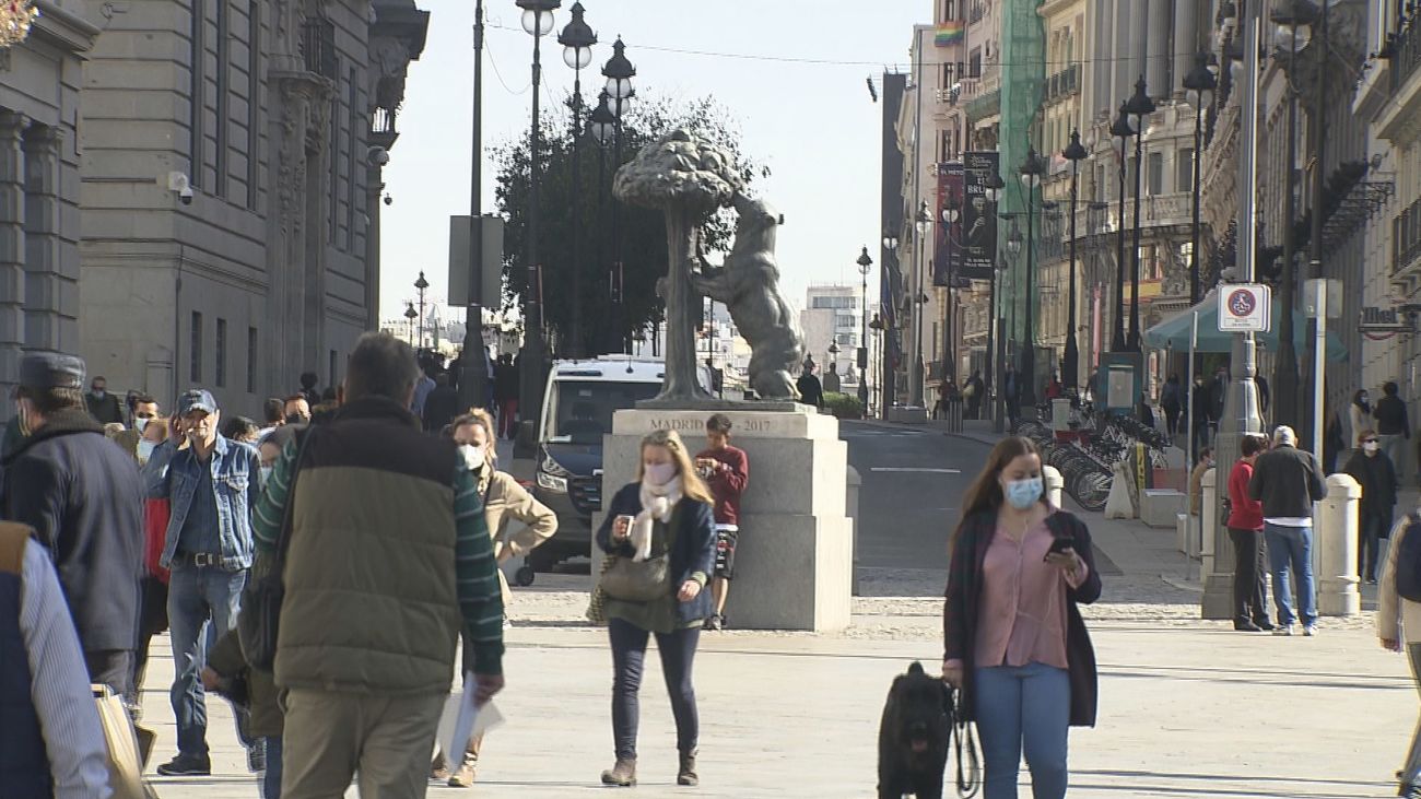 Un grupo de personas pasea por la Puerta del Sol