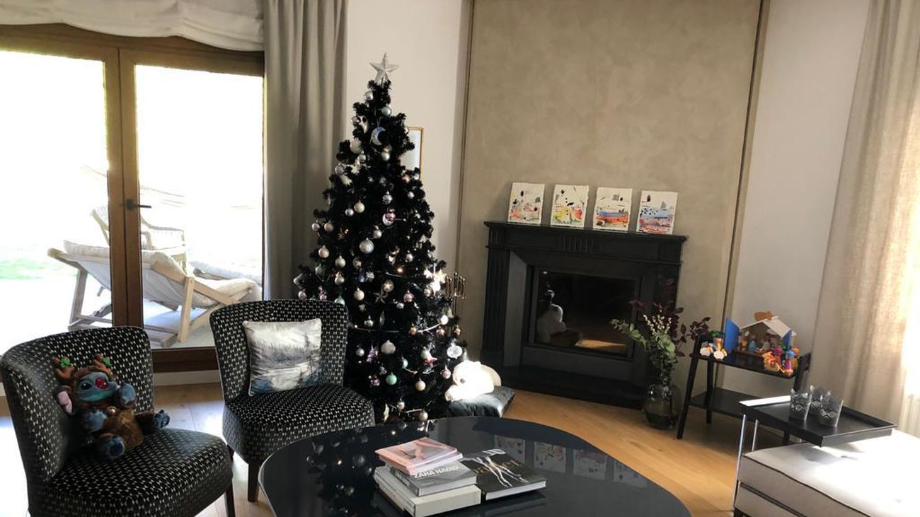 Este es el salón de una enorme casa de La Moraleja. Con su chimenea, un árbol de Navidad negro y un pequeño belén artesanal .