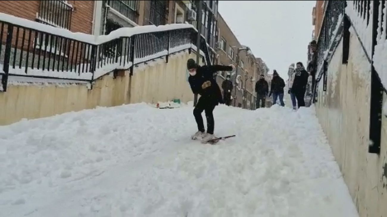 Los madrileños tiran de ingenio con trineos y esquíes en las calles de la Comunidad