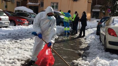 Una médico del 112 barre la nieve de una calle de Majadahonda para poder trasladar a un paciente con Covid