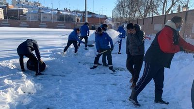 Voluntarios quitan la nieve del estadio del Navalcarnero