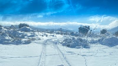 Un vecino de El Molar retira con una excavadora la nieve que mantiene incomunicadas varias fincas