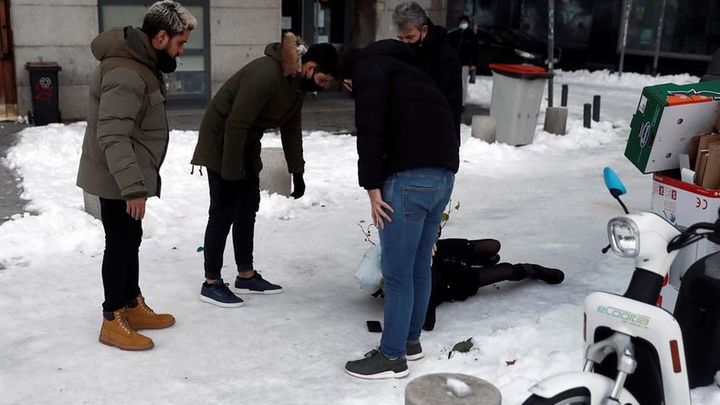 Madrileños atienden a una persona en el suelo tras caer por el hielo / EFE