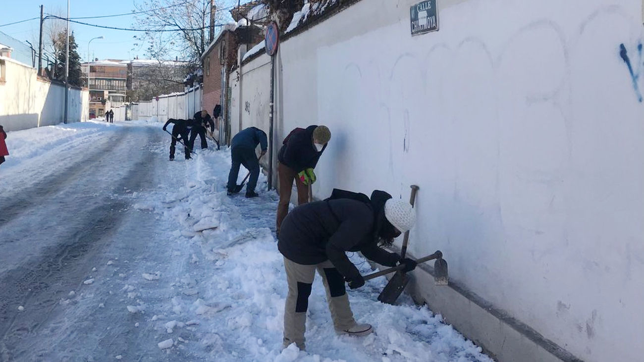 Vecinos retiran nieve para abrir un paso hacia el centro de salud de Aguacate, Carabanchel