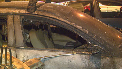 Un coche queda completamente calcinado por el incendio de un contenedor en Vallecas