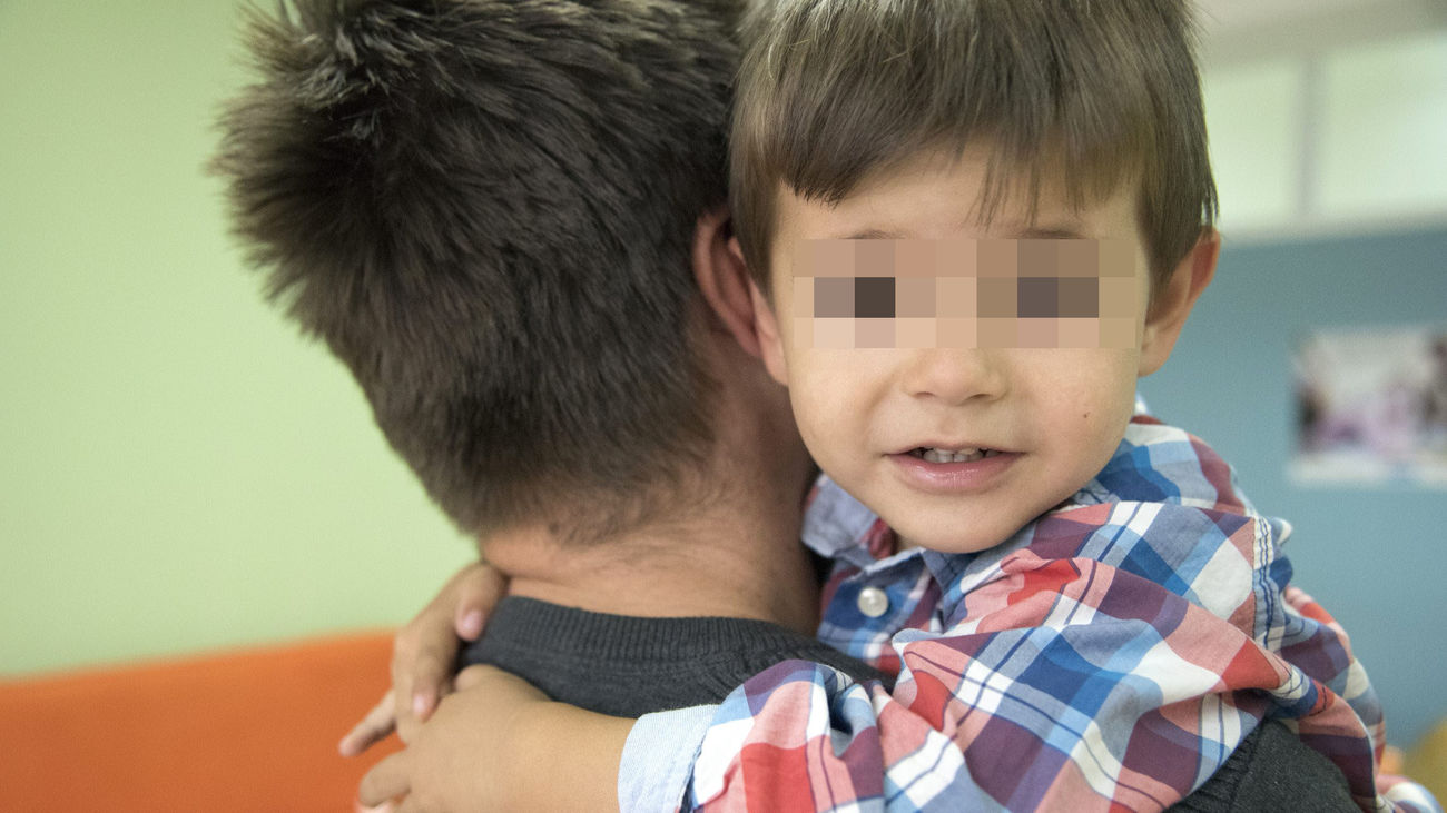 Menor en brazos de su padre de acogida