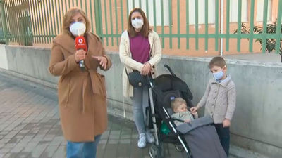 Una madre acude con sus dos hijos pequeños a la mesa electoral