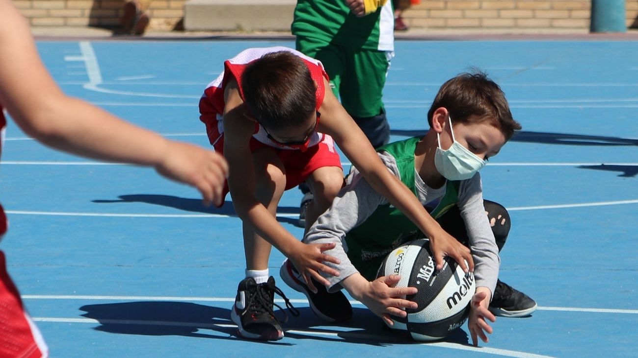 Lucha por el balón en un encuentro de baloncesto infantil