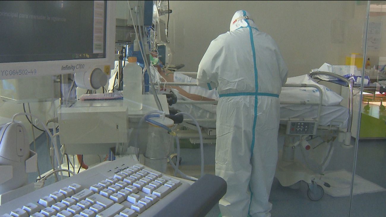 Un sanitario con equipo de protección atiende a una persona enferma en una unidad Covid