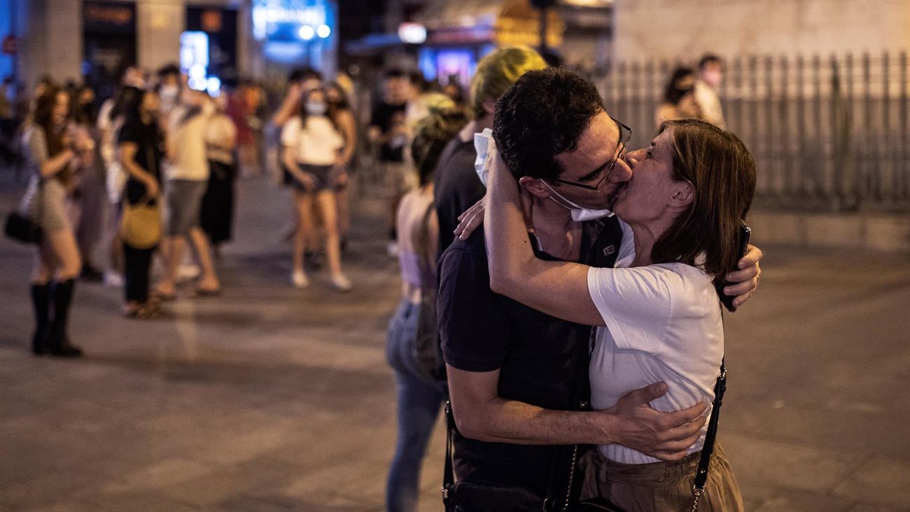Un pareja celebra el fin del uso obligatorio de mascarillas en exteriores en la Puerta del Sol