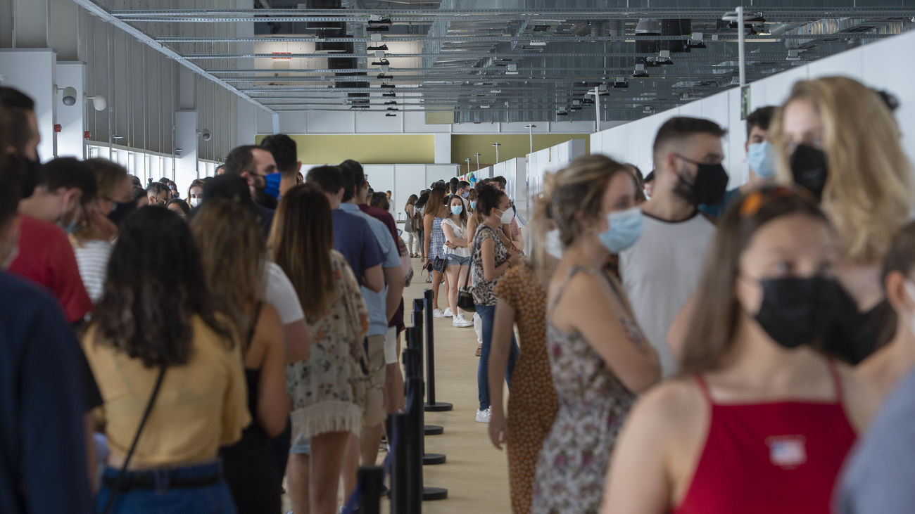 Varios jóvenes esperan en una fila para vacunarse