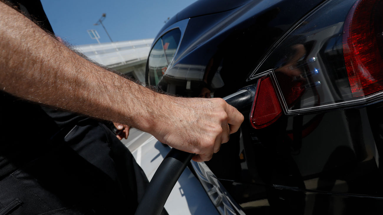 Una persona recarga su vehículo eléctrico en un punto de recarga