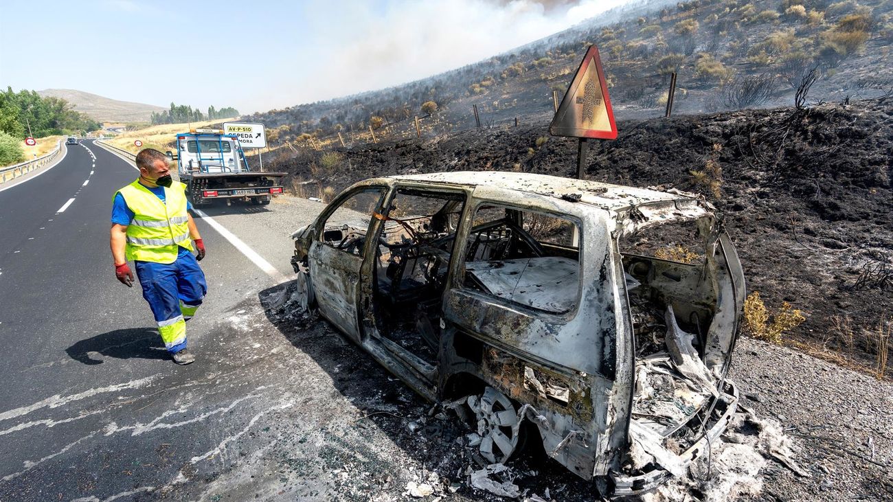 Vista del vehículo incendiando que ha generado un fuego a la altura del kilómetro 39 de la N-502 de Ávila este sábado