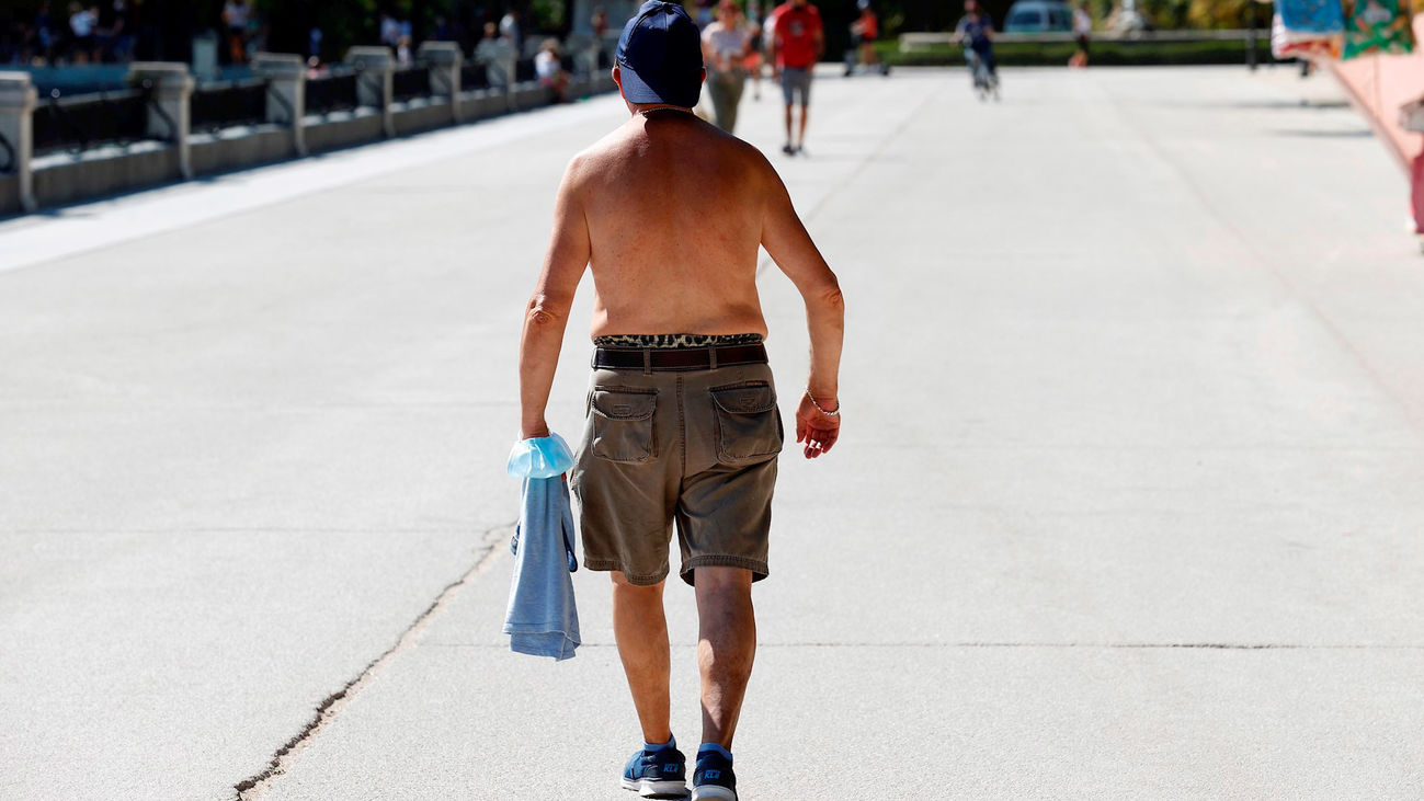 Un hombre pasea por el Parque de El Retiro durante los días de la ola de calor