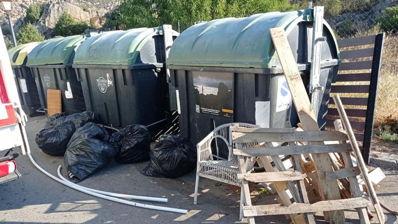 Restos de mobiliario y otros residuos depositados junto a contenedores de basuras domésticas