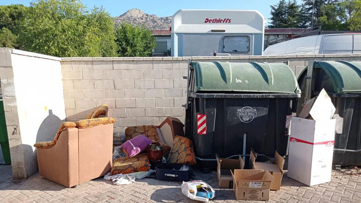 Sofás, maletas, cojines, restos de embalajes, tirados junto a contenedores / AYTO DE MANZANARES EL REAL