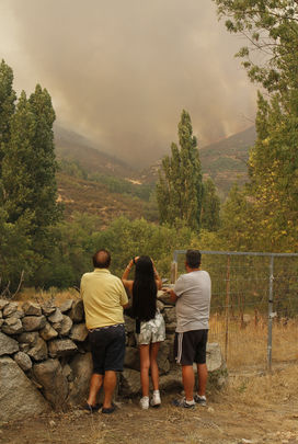 Tres vecinos contemplan el incendio en el término de Navalacruz (Ávila) / EUROPA PRESS