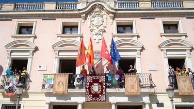 Las peñas cuelgan sus estandartes y pañoletas en la fachada del Ayuntamiento de Alcalá para dar comienzo a las fiestas