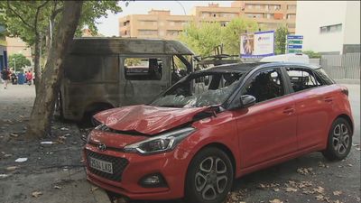 Coches calcinados tras la quema vandálica de contenedores en Puente de Vallecas