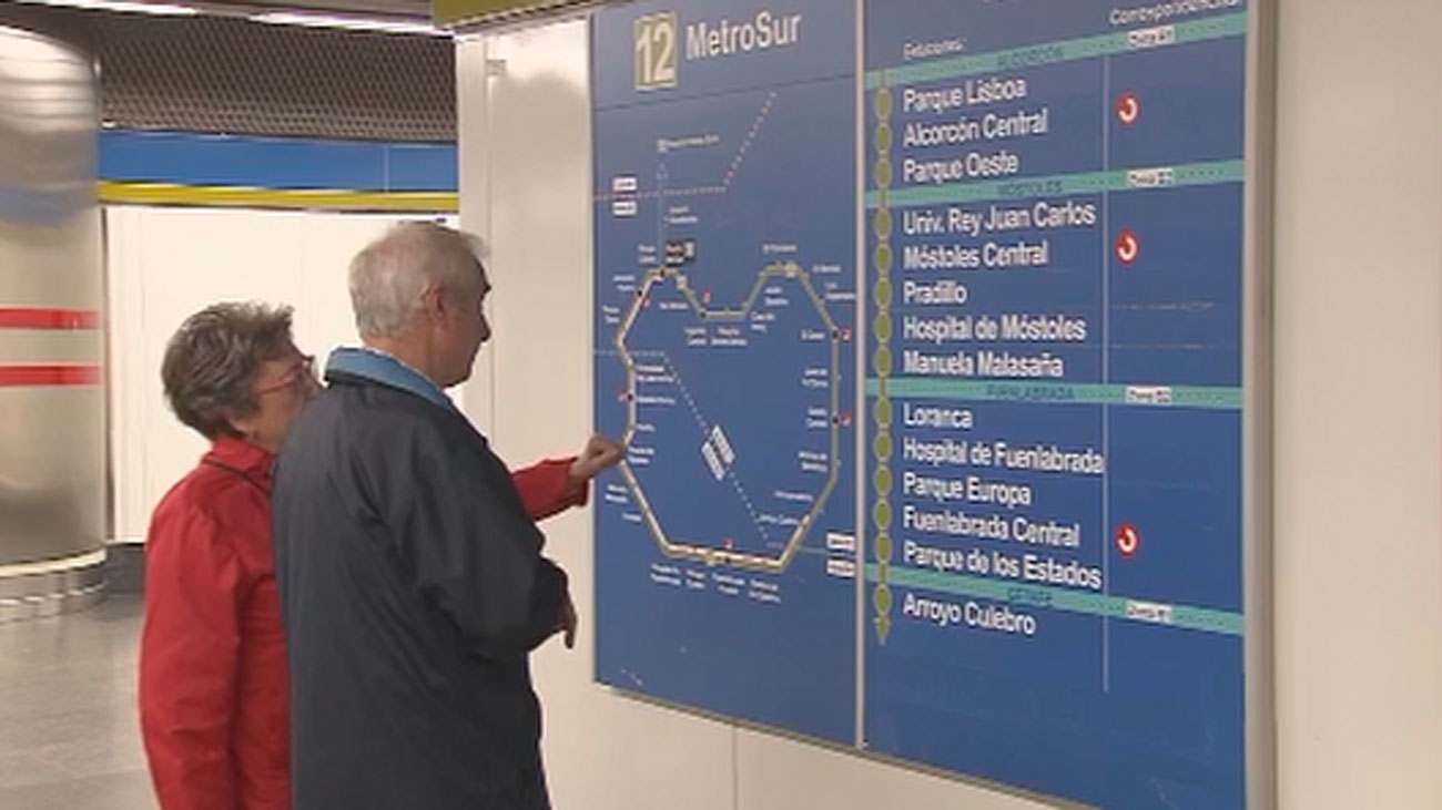 Una pareja mayor consulta un panel informativo en la red de MetroSur