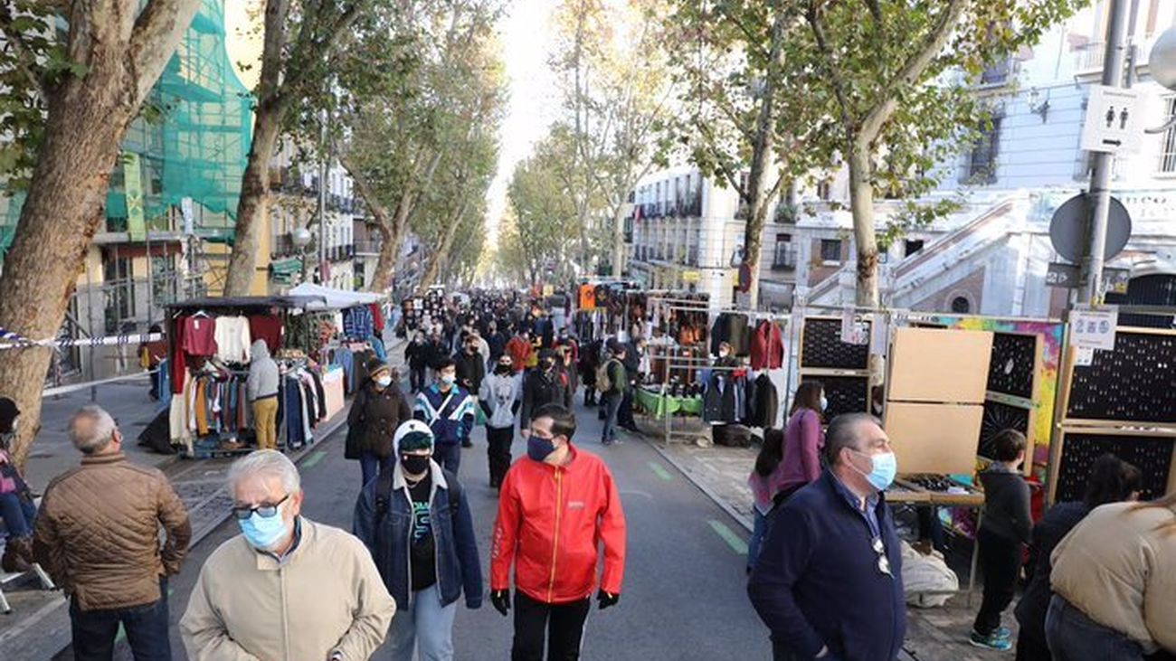 Personas con mascarilla pasean por El Rastro de Madrid