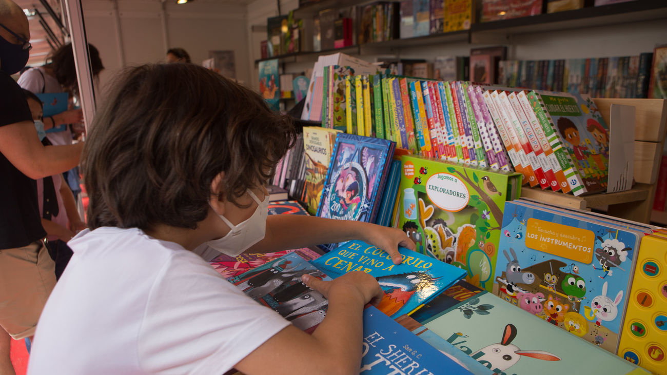 Un niño busca un cuento en un estand de libros