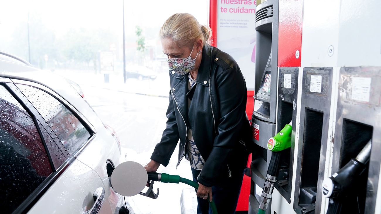 Una mujer echa gasolina en su coche
