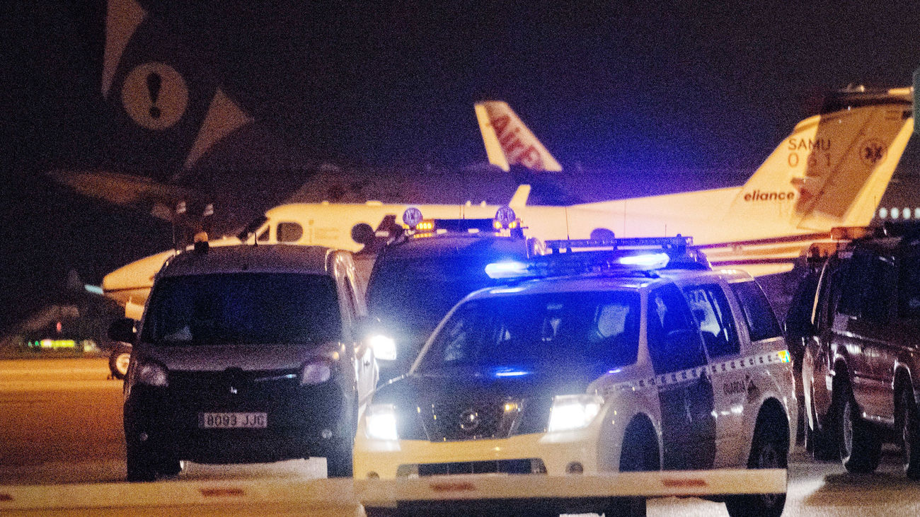 Miembros de la Guardia Civil y de seguridad del aeropuerto de Palma de Mallorca buscan por las pistas y sus aledaños a un grupo de pasajeros que ha obligado a cerrar la instalación.