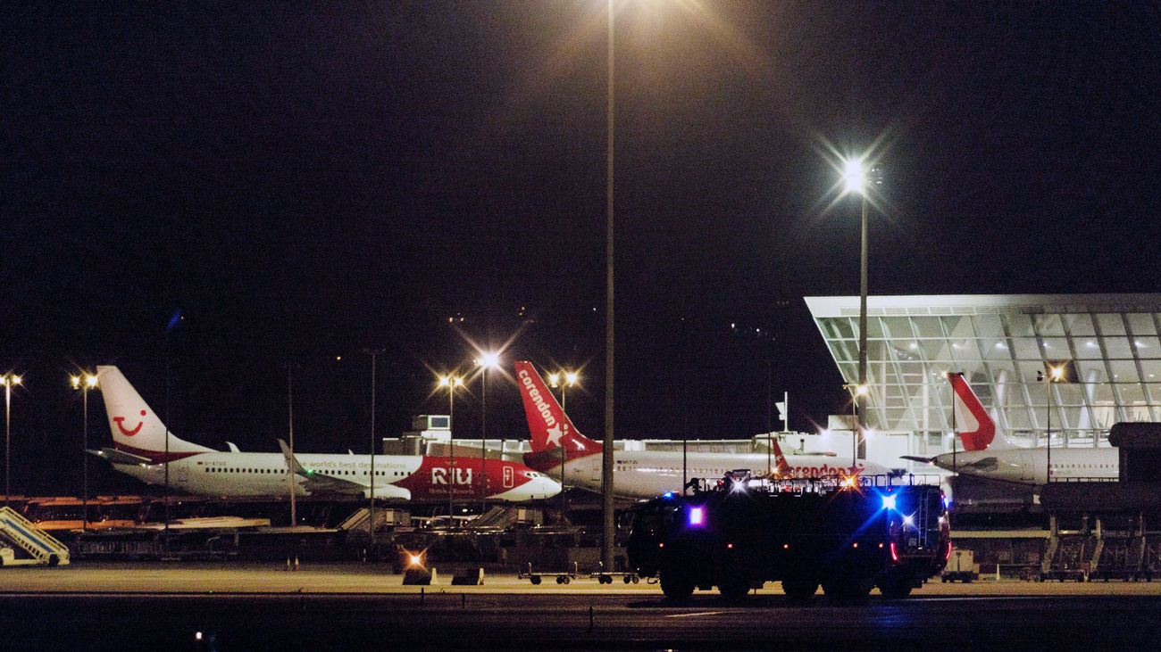 Miembros de la Guardia Civil y de seguridad del aeropuerto de Palma de Mallorca buscan por las pistas y sus aledaños a un grupo de pasajeros que ha obligado a cerrar la instalación.