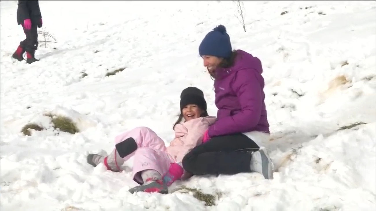 Los madrileños aprovechan las primeras nevadas en Navacerrada y Cotos