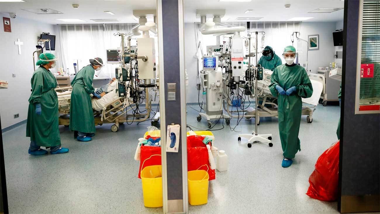 Sanitarios equipados con trajes de protección atienden a enfermos de Covid en la UCI