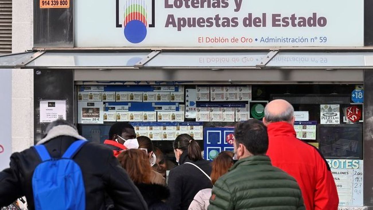 Fila de personas para comprar lotería en una administración de la Puerta del Sol