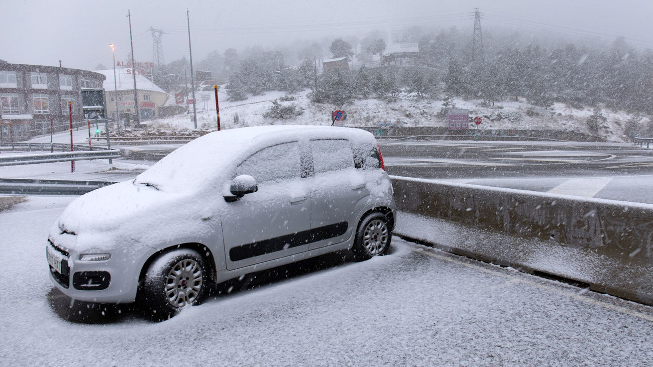 Un coche cubierto de nieve en el Puerto de Navacerrada