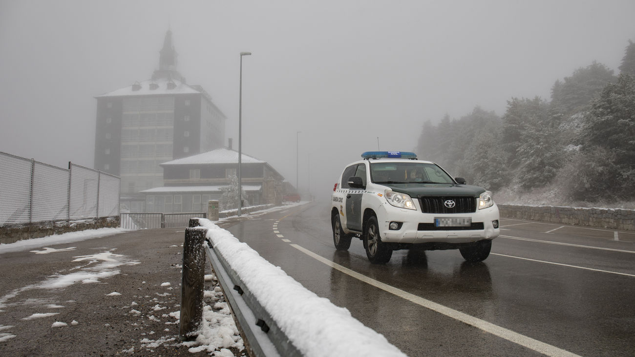 Un vehículo de la Guardia Civil pasa por el Puerto de Navacerrada, en la sierra de Guadarrama