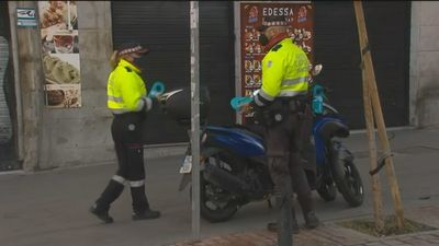 Agentes de movilidad reparten folletos en Madrid para saber cómo aparcar correctamente motos, bicis y patinetes