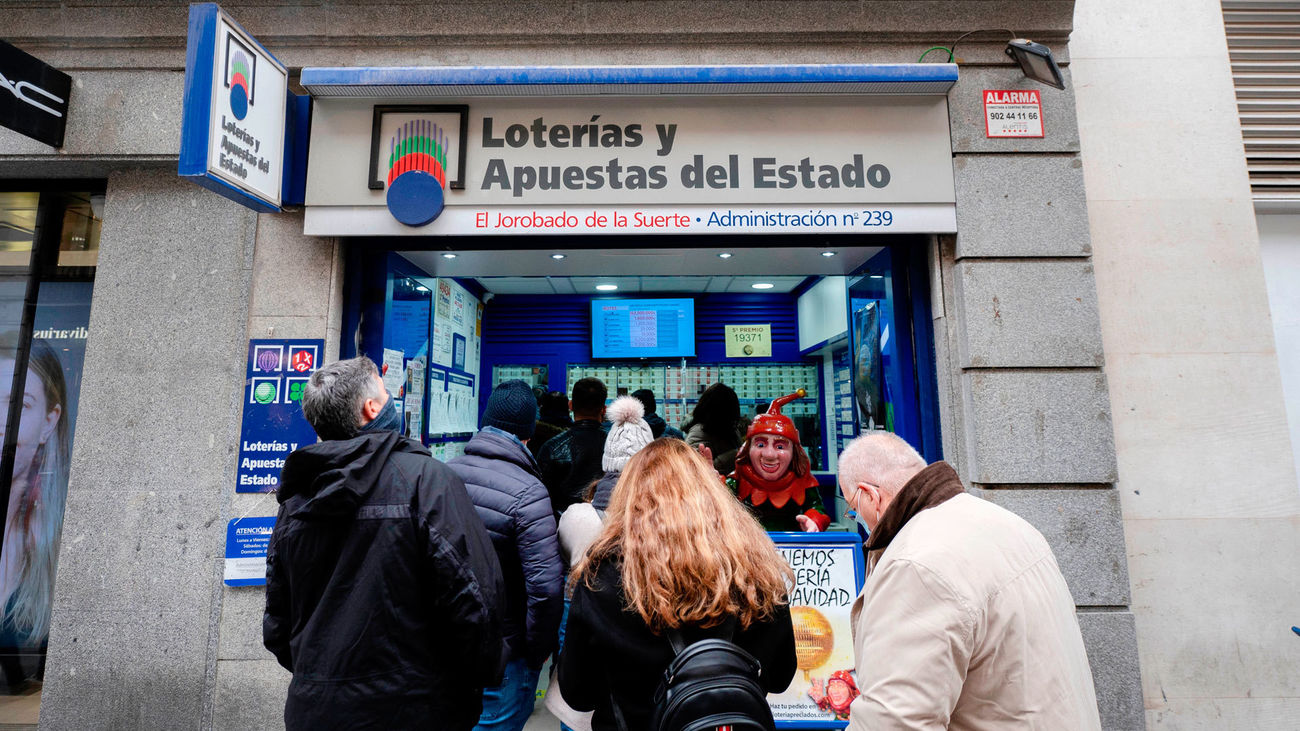 Varias personas hacen cola en la Administración de Loterías 'El jorobado de la suerte', en Madrid