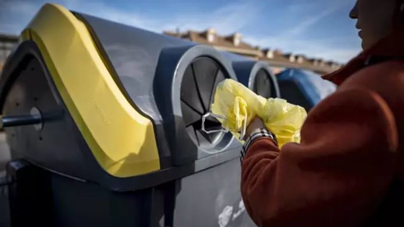 Una persona recicla sus plásticos en el contenedor amarillo