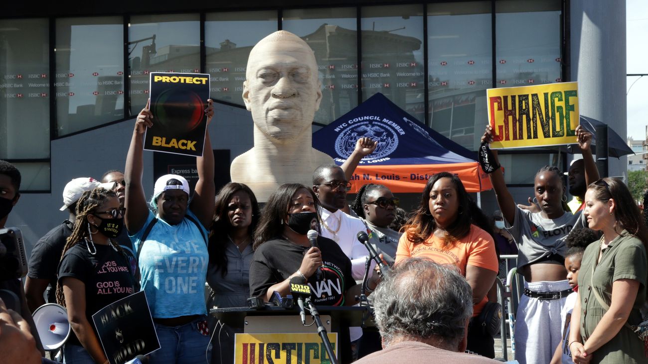 Manifestantes enfrene de una estatua de George Floyd