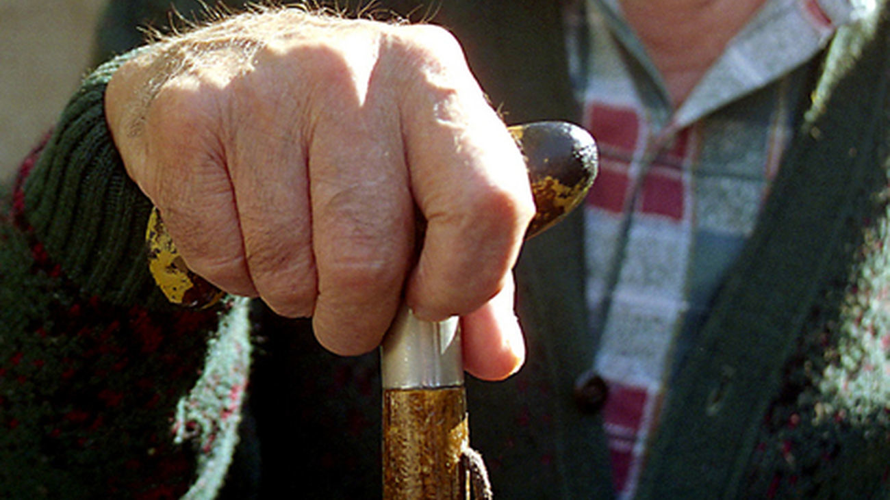 Una persona mayor sostiene su bastón