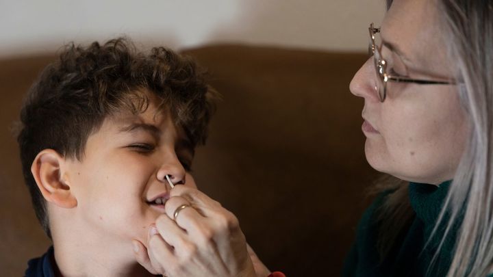 Una madre realiza un test de antígenos a su hijo / EP