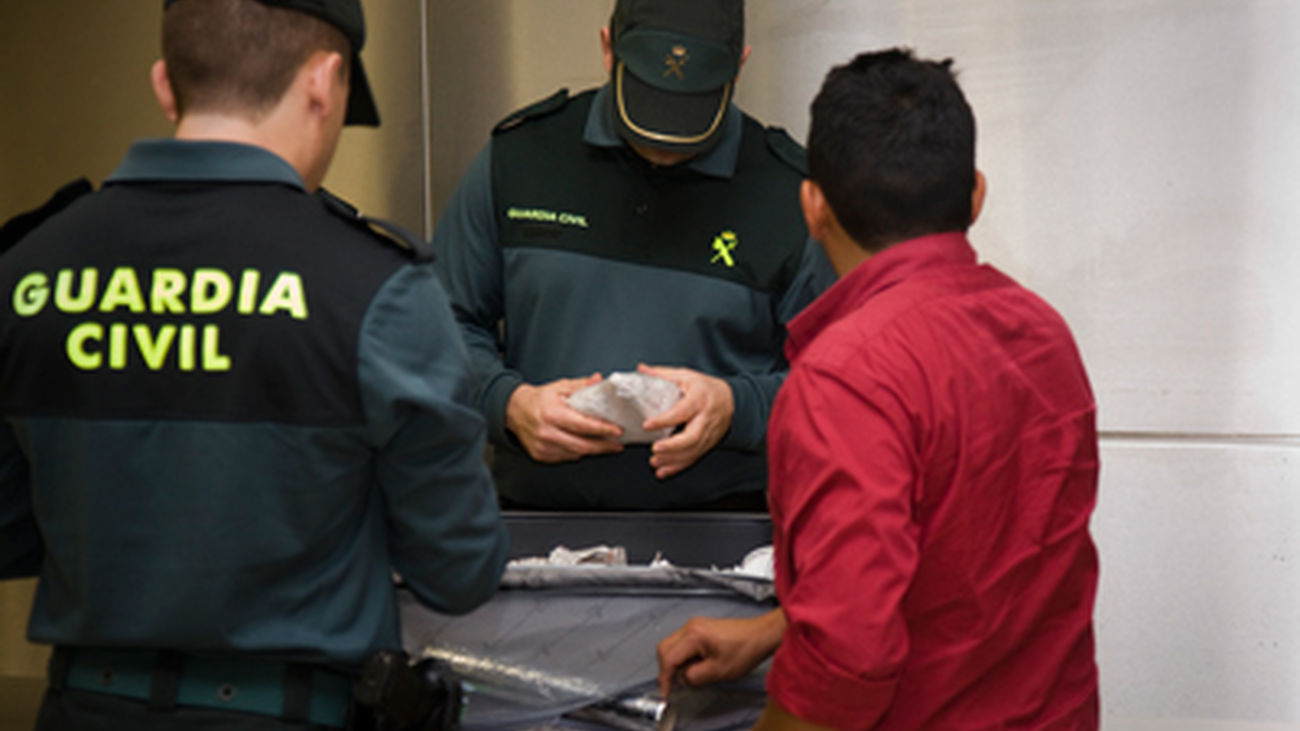 Agentes de la Guardia Civil realiza un registro en el equipaje de una persona, en  Barajas