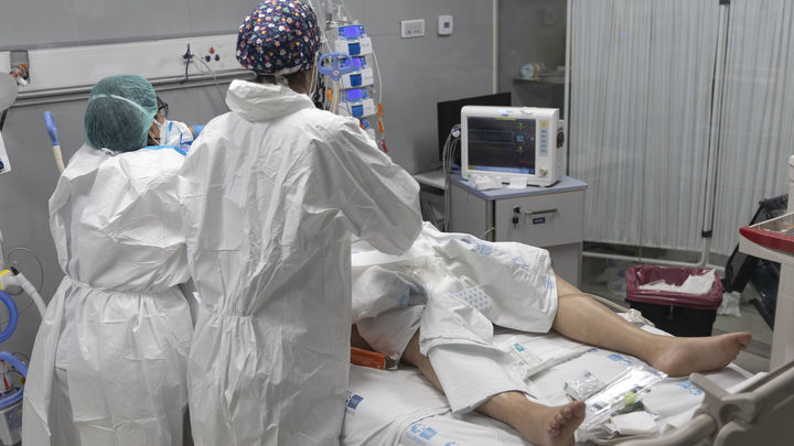 Dos sanitarios alrededor de un paciente ingresado en la UCI del Hospital Enfermera Isabel Zendal
