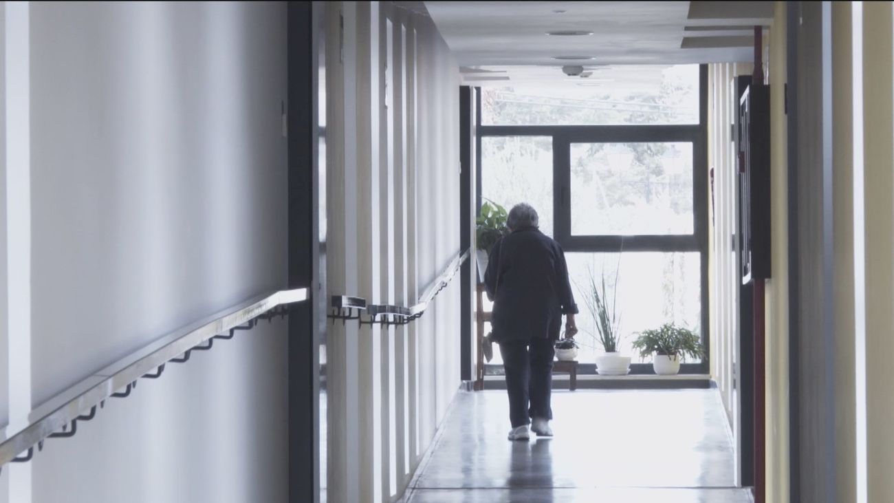 Una mujer camina por el pasillo de una residencia de mayores