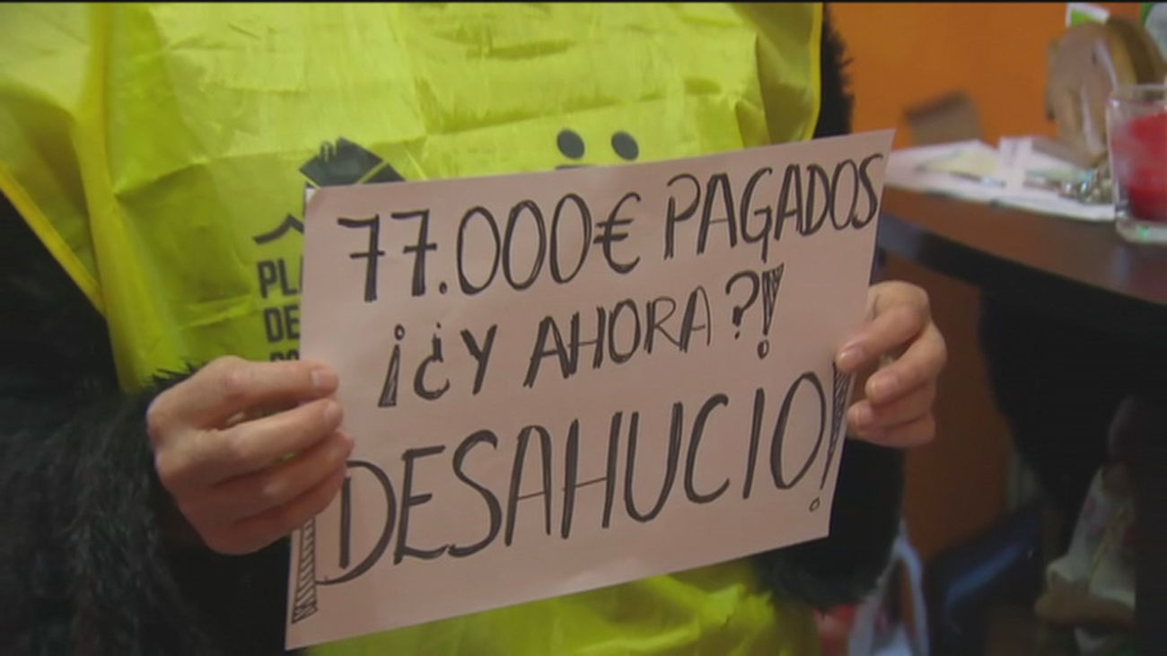 Una persona exhibe un cartel reclamando detener su desahucio en Madrid